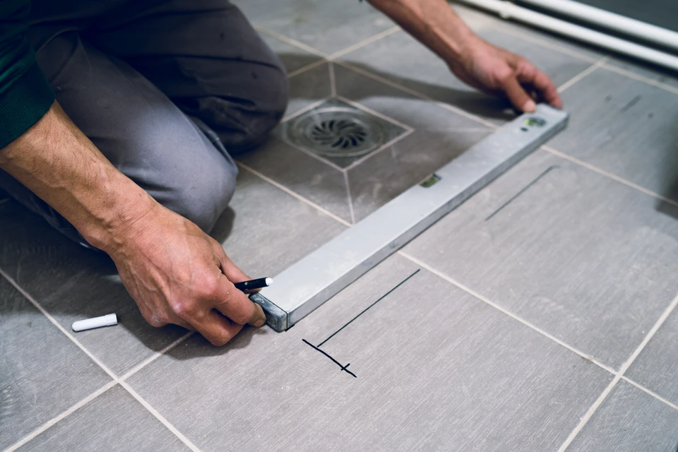 Artisan plâtrier en intérieur appliquant avec soin une plaque de plâtre sur une paroi, tenant fermement la plaque tandis qu'il réalise la fixation, illustrant la rigueur et le savoir-faire artisanal. Scène professionnelle dans un chantier de rénovation intérieure, mettant en évidence la technique et l'attention au détail du travail de plâtrerie.