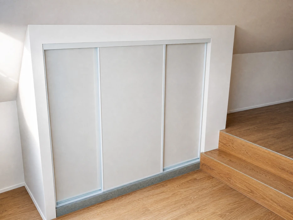 Un ouvrier en casque bleu et salopette installe une cloison sèche dans un intérieur en rénovation